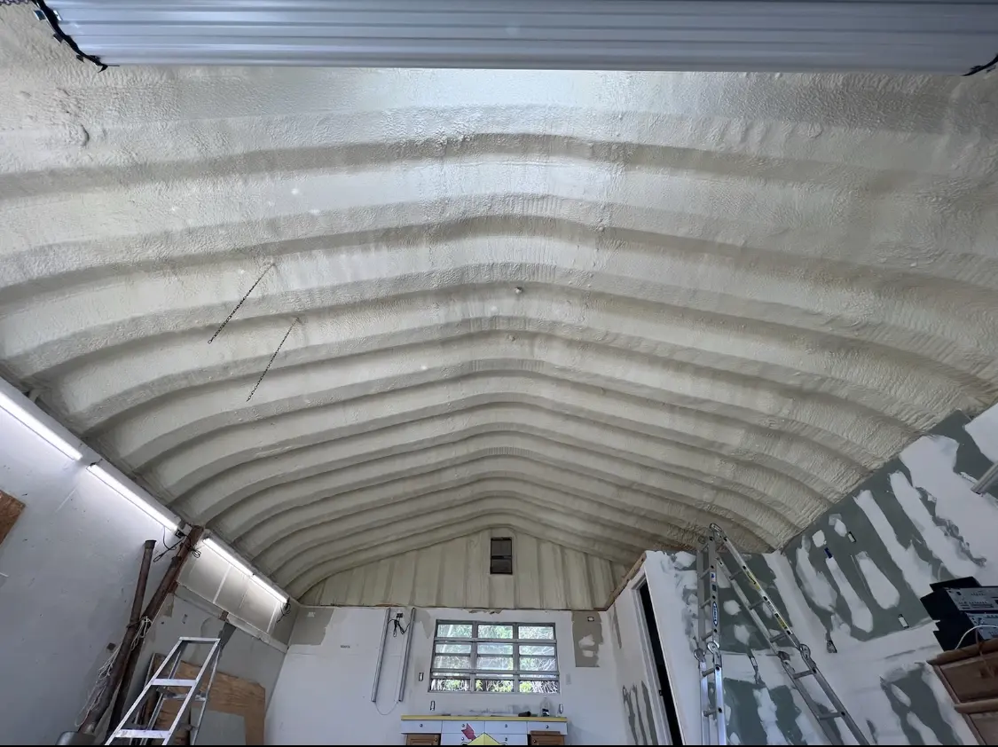 Spray polyurethane foam applied to the underside of a metal roof deck in Prien